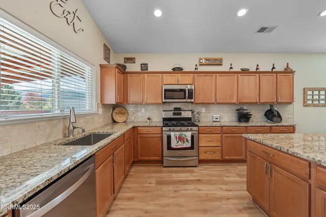 a kitchen with stainless steel appliances granite countertop a sink stove and refrigerator
