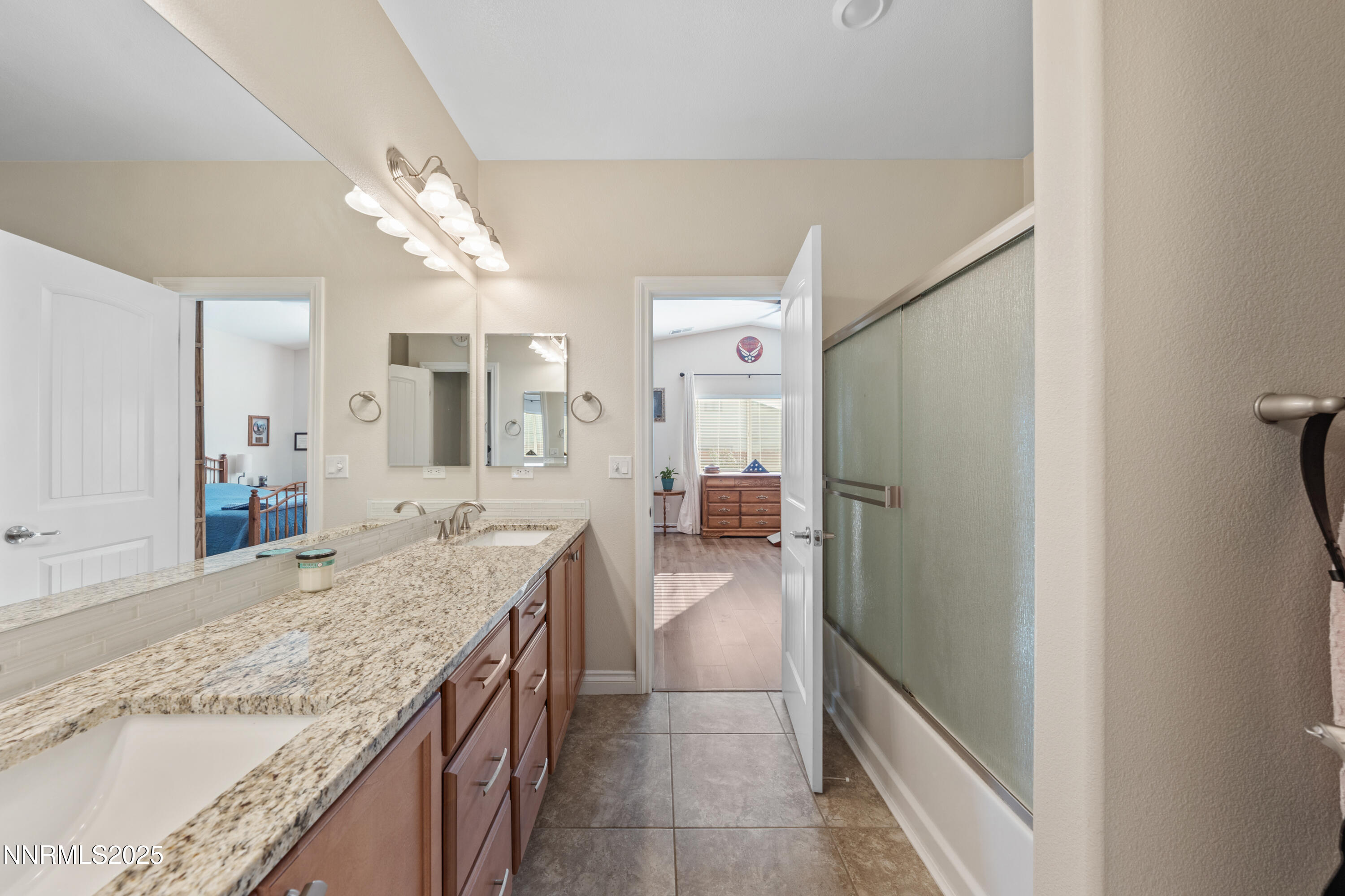 18520 Silverbell Court Reno, NV 89508 - Photo 38 of 60 a bathroom with a granite countertop sink a mirror and a shower