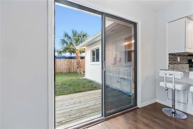 a view of a hallway with a dining room view and wooden floor