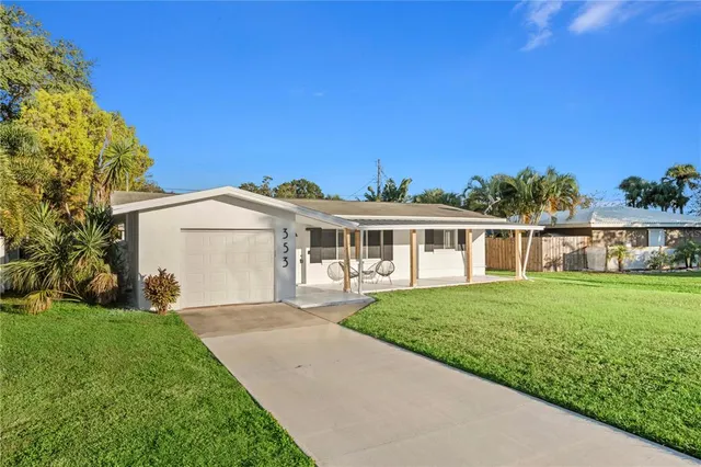 a front view of a house with a garden and yard