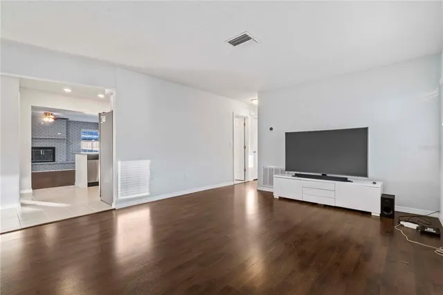 a view of a livingroom with wooden floor and a flat screen tv