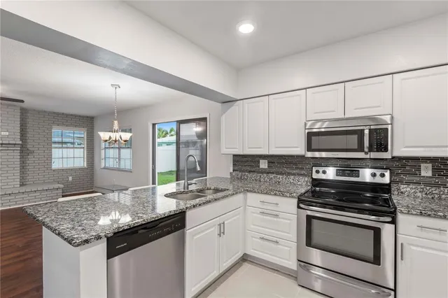 a kitchen with stainless steel appliances granite countertop a stove and cabinets