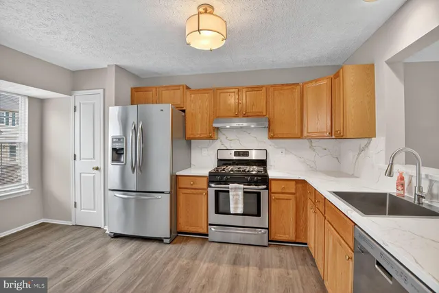 a kitchen with a refrigerator sink and cabinets