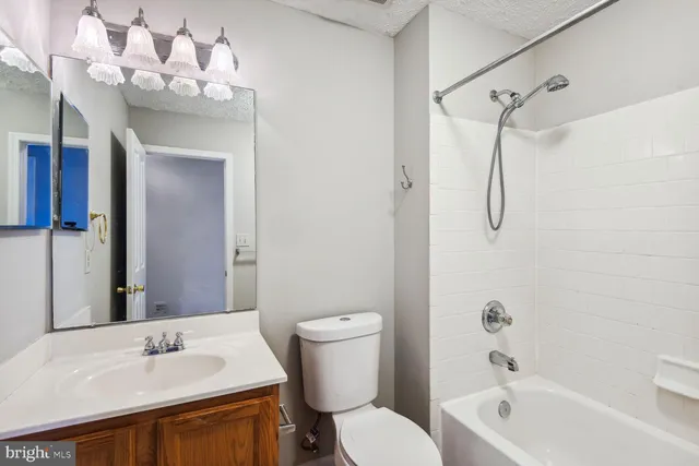 a bathroom with a sink vanity mirror and toilet