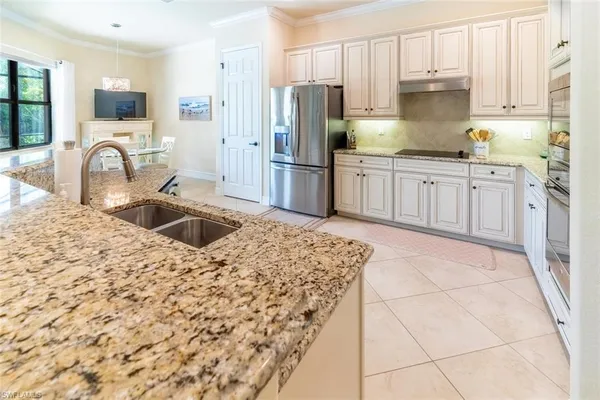 a kitchen with stainless steel appliances granite countertop a sink refrigerator and cabinets