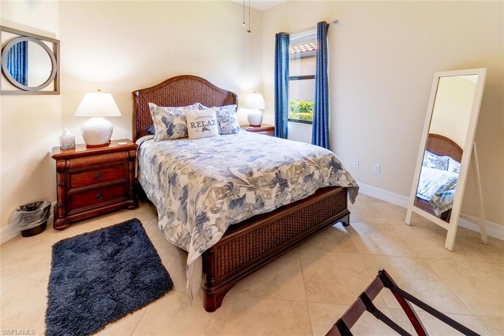 9372 Vercelli Court Naples, FL 34113 - Photo 29 of 50 a bed sitting in a bedroom next to a window