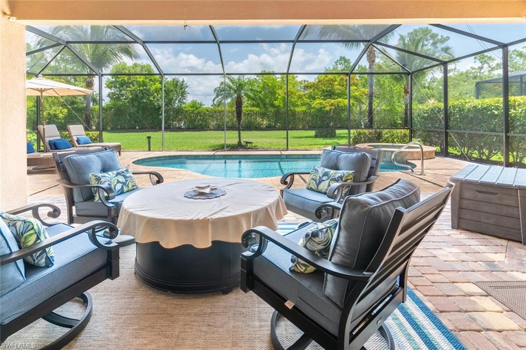 9372 Vercelli Court Naples, FL 34113 - Photo 35 of 50 a view of a patio with a table chairs and a umbrella