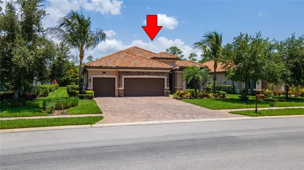 a front view of a house with garage and plants