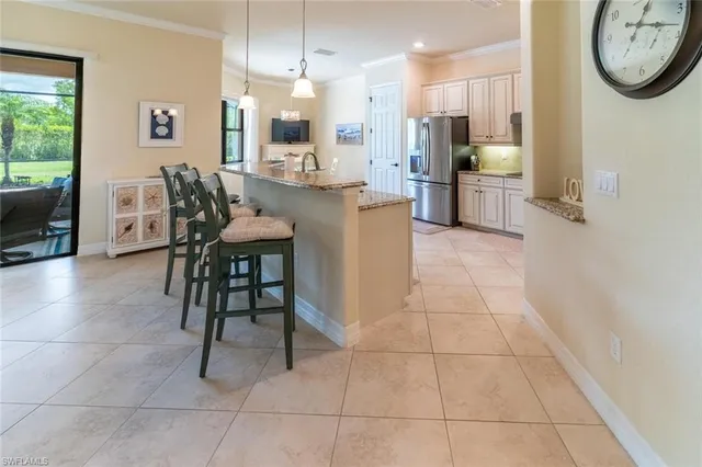 a very nice looking open dining room with kitchen island granite countertop a table and a chair