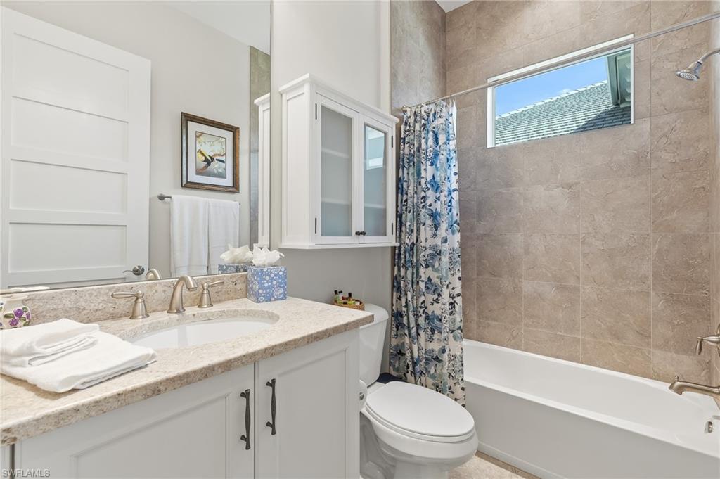 6939 Cay Court Naples, FL 34113 - Photo 13 of 30 a bathroom with a granite countertop sink toilet and shower