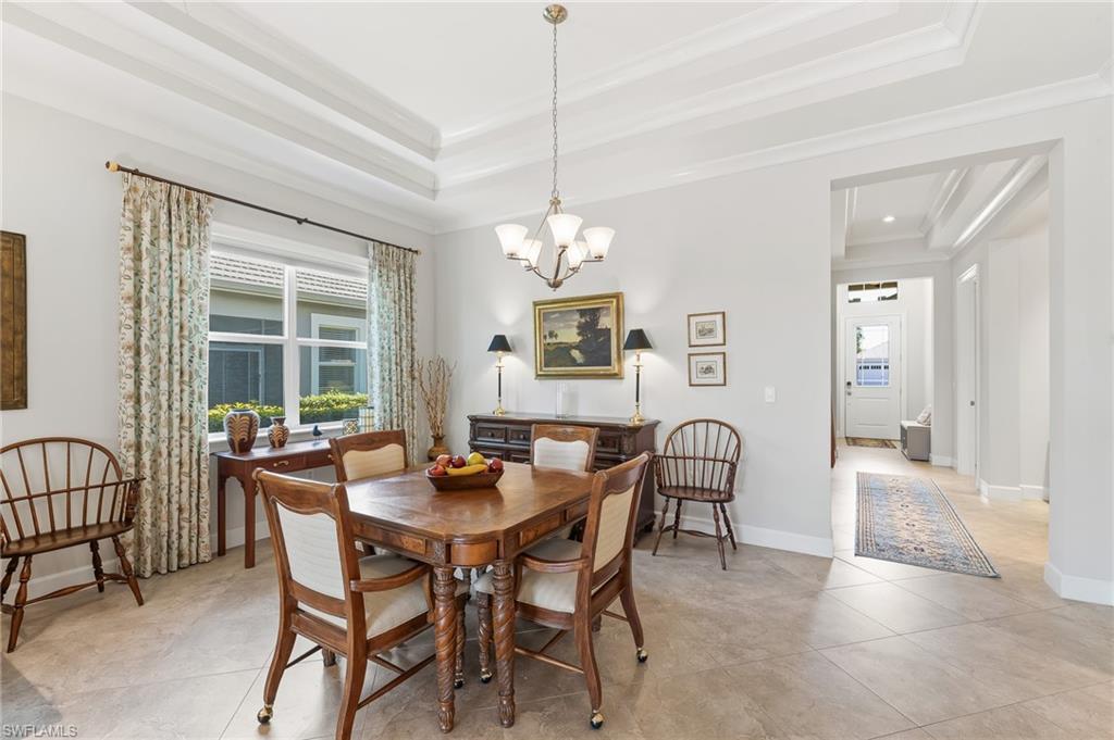 6939 Cay Court Naples, FL 34113 - Photo 9 of 30 a dining room with furniture a chandelier and wooden floor