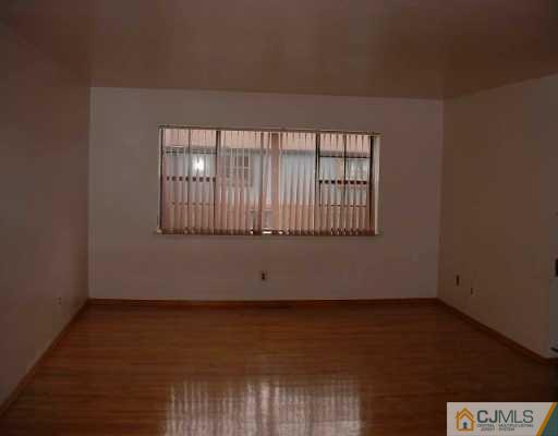 5705 Hana Road Edison, NJ 08817 - Photo 2 of 8 an empty room with wooden floor and windows