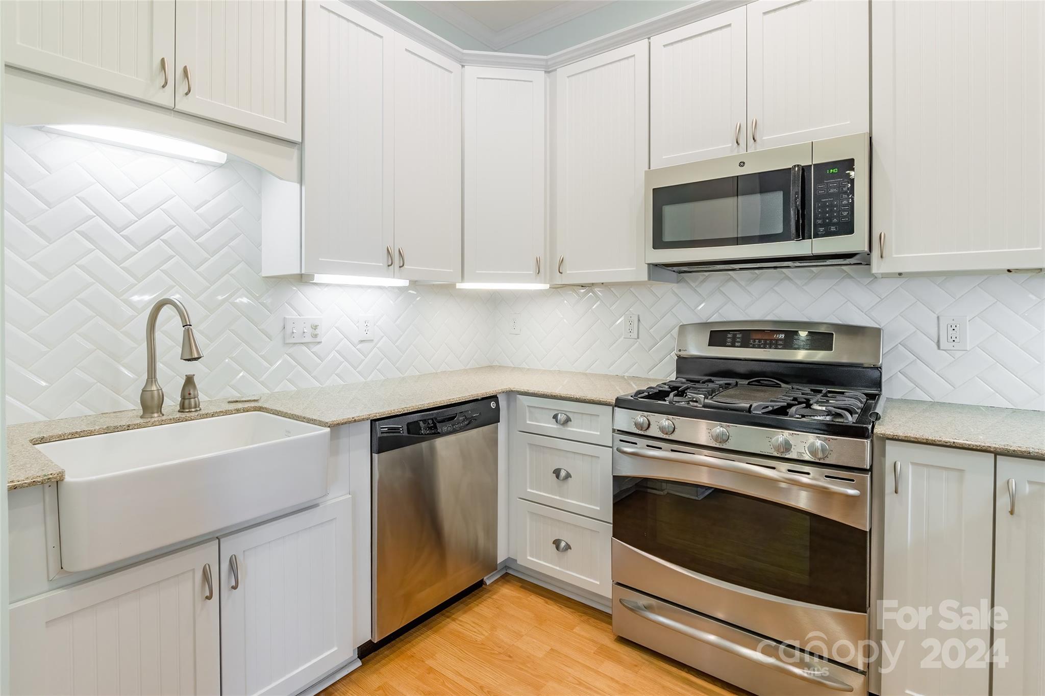 738 Portpatrick Place Fort Mill, SC 29708 - Photo 18 of 27 a kitchen with white cabinets and stainless steel appliances