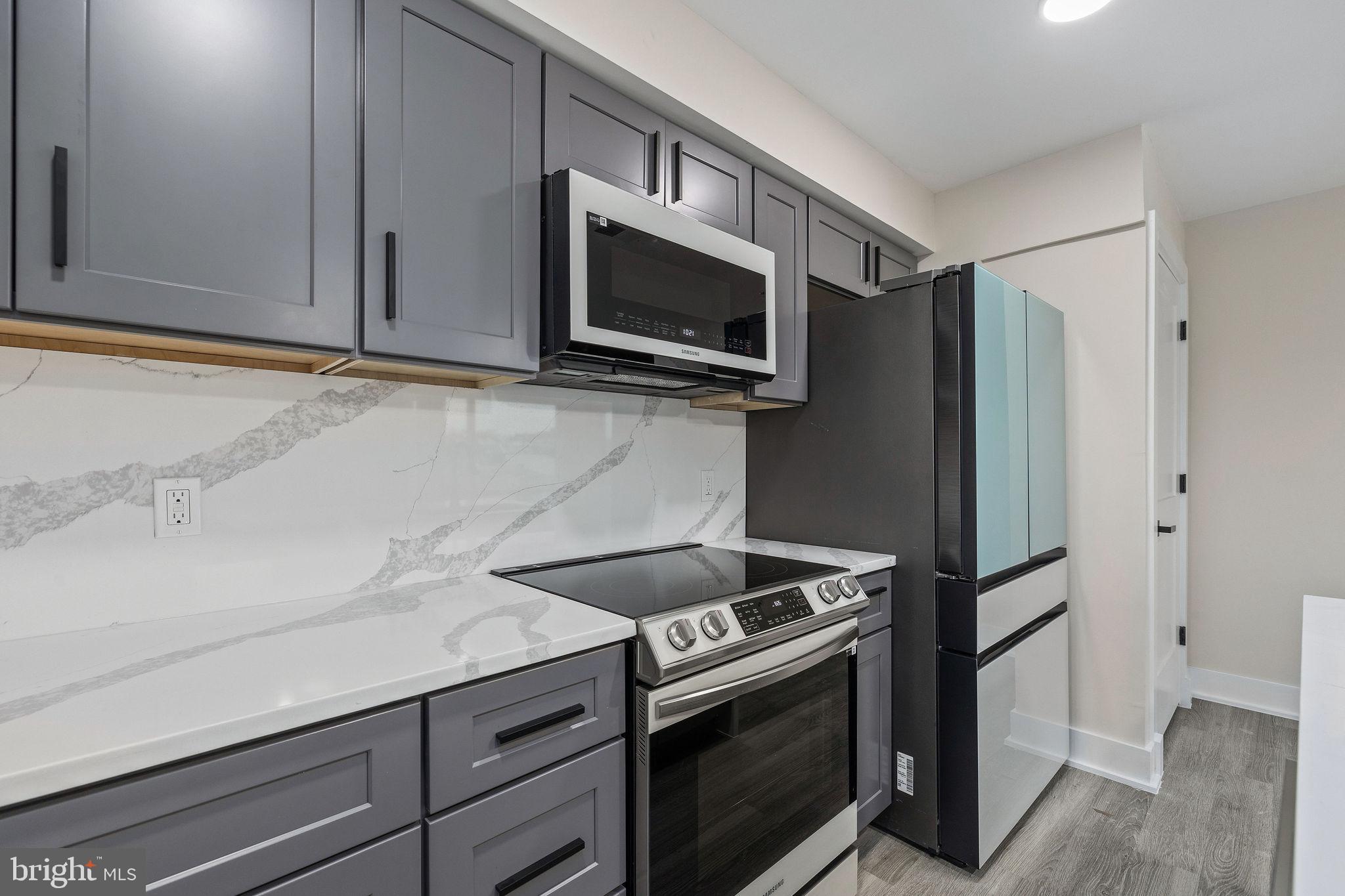 3517 14th Street Northwest, Unit 301 Washington, DC 20010 - Photo 11 of 27 a kitchen with stainless steel appliances white cabinets and a stove