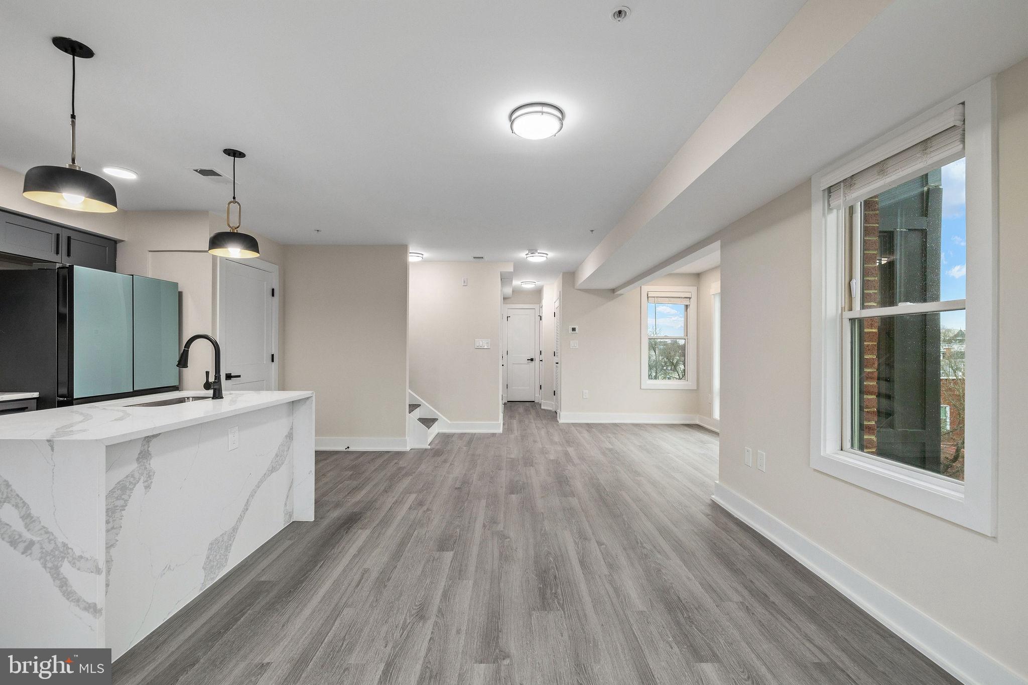 3517 14th Street Northwest, Unit 301 Washington, DC 20010 - Photo 13 of 27 a large kitchen with sink a refrigerator and a wooden floor