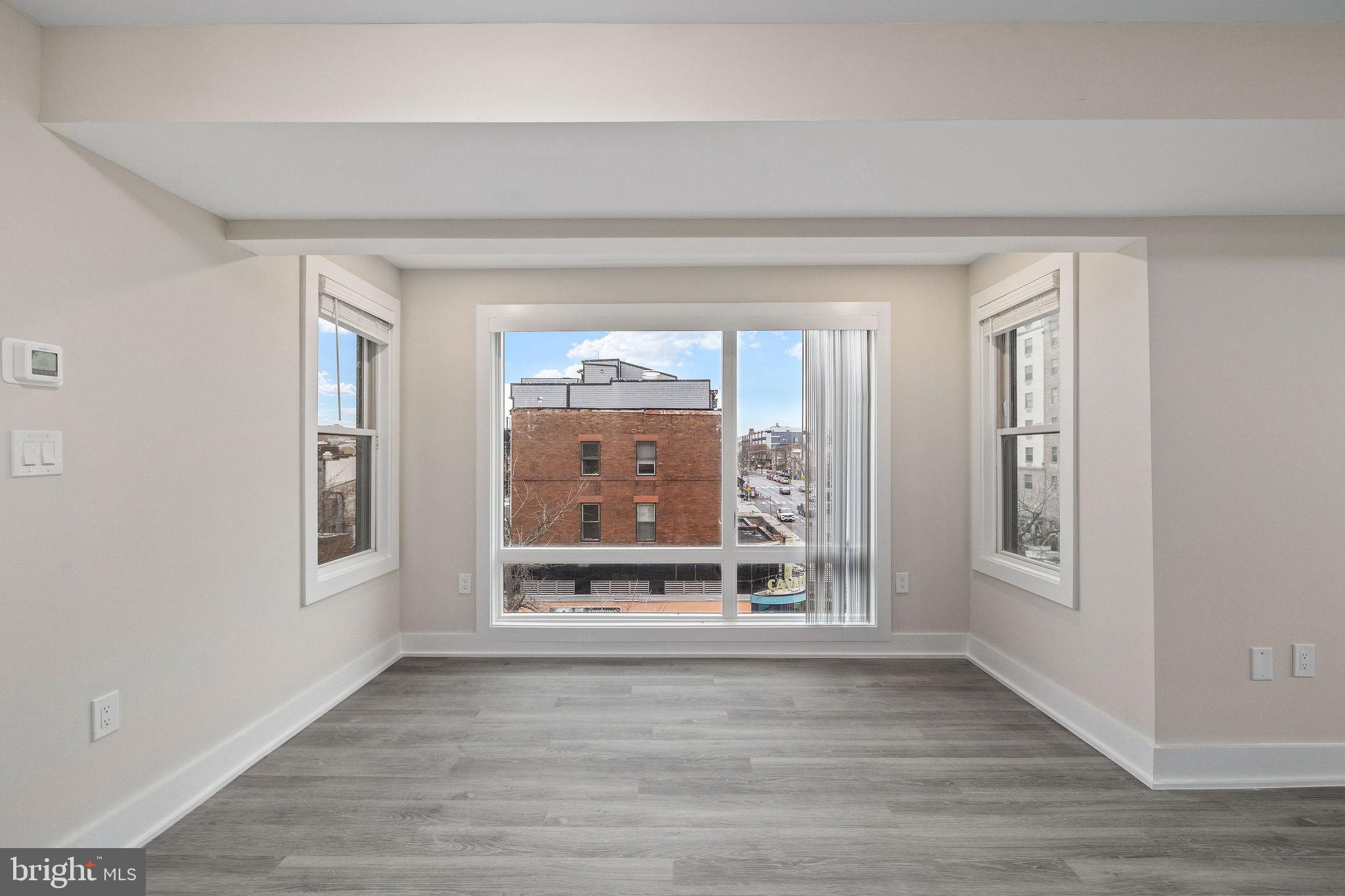 3517 14th Street Northwest, Unit 301 Washington, DC 20010 - Photo 15 of 27 a view of an empty room with wooden floor and a window