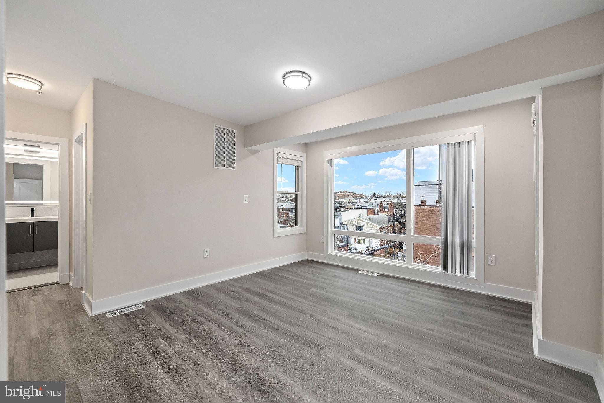 3517 14th Street Northwest, Unit 301 Washington, DC 20010 - Photo 17 of 27 a view of an empty room with wooden floor and a window