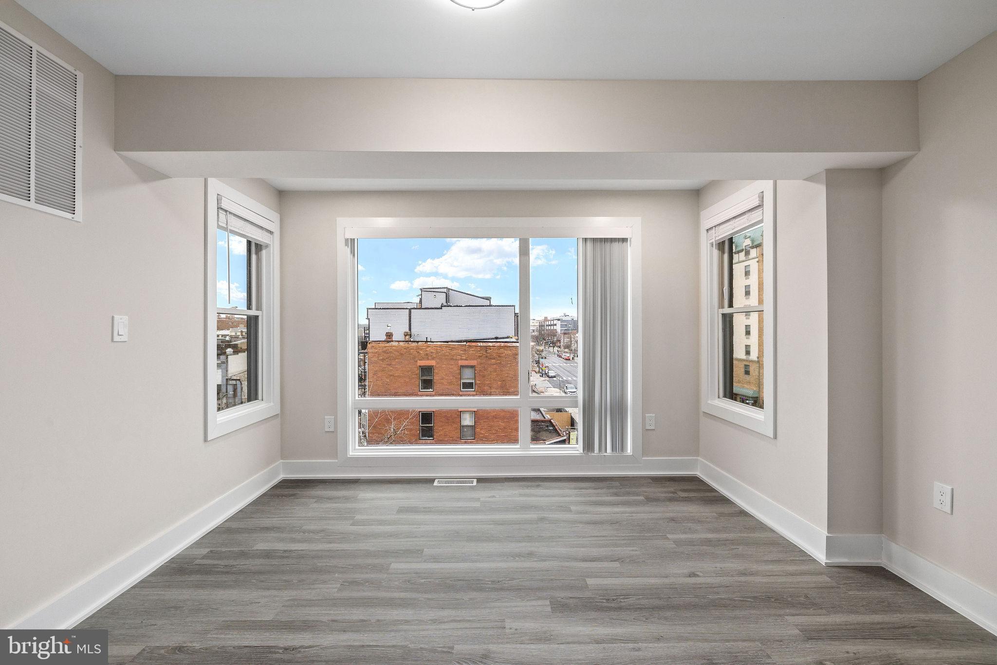 3517 14th Street Northwest, Unit 301 Washington, DC 20010 - Photo 18 of 27 a view of an empty room with window and wooden floor