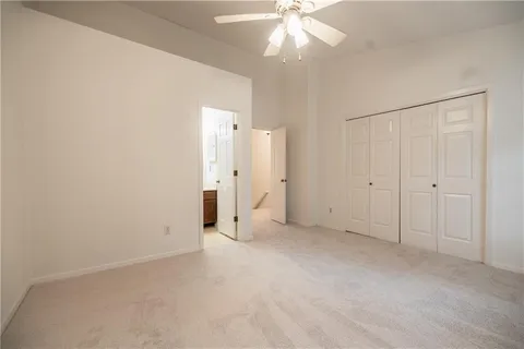 an empty room with closet and a chandelier fan
