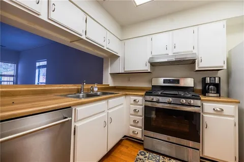 a kitchen with stainless steel appliances white cabinets and a stove top oven