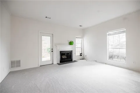 an empty room with fireplace and windows