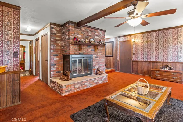 a living room with furniture a ceiling fan and a next to a window
