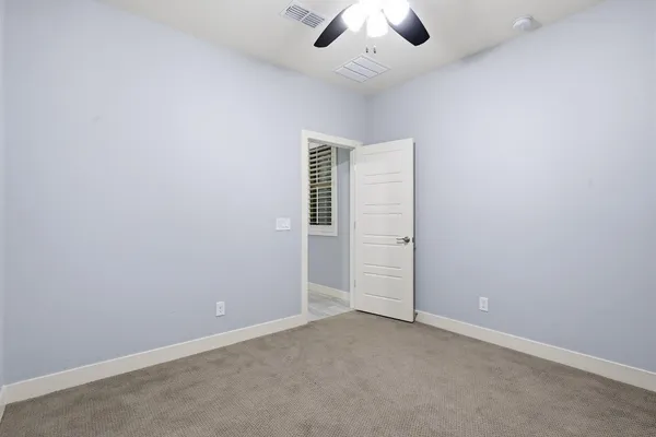 an empty room with chandelier fan
