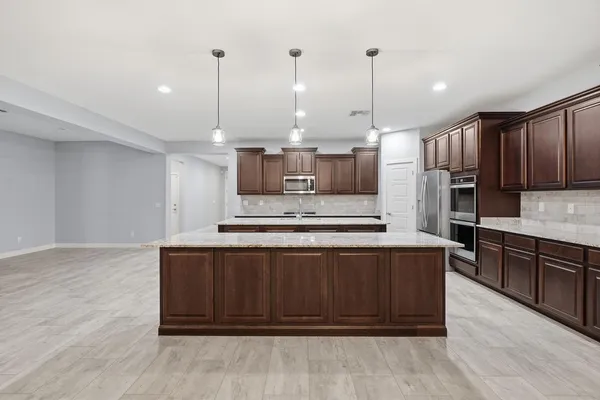 a kitchen with granite countertop kitchen island a sink and a wooden floor