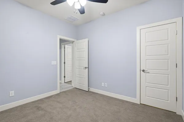 an empty room with a window and a ceiling fan