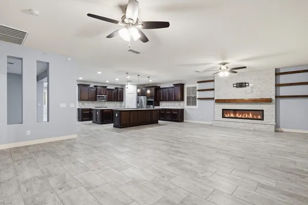 a view of a kitchen with a stove cabinets a ceiling fan and wooden floor