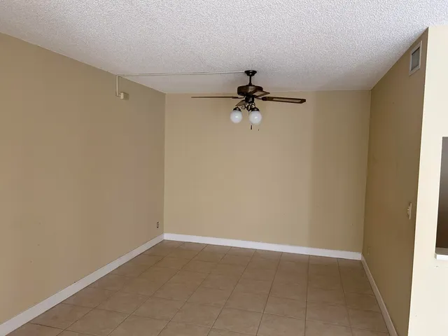 a view of empty room with a ceiling fan and carpet