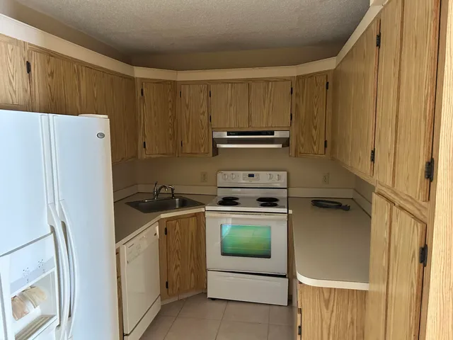 a kitchen with a refrigerator sink stove and cabinets