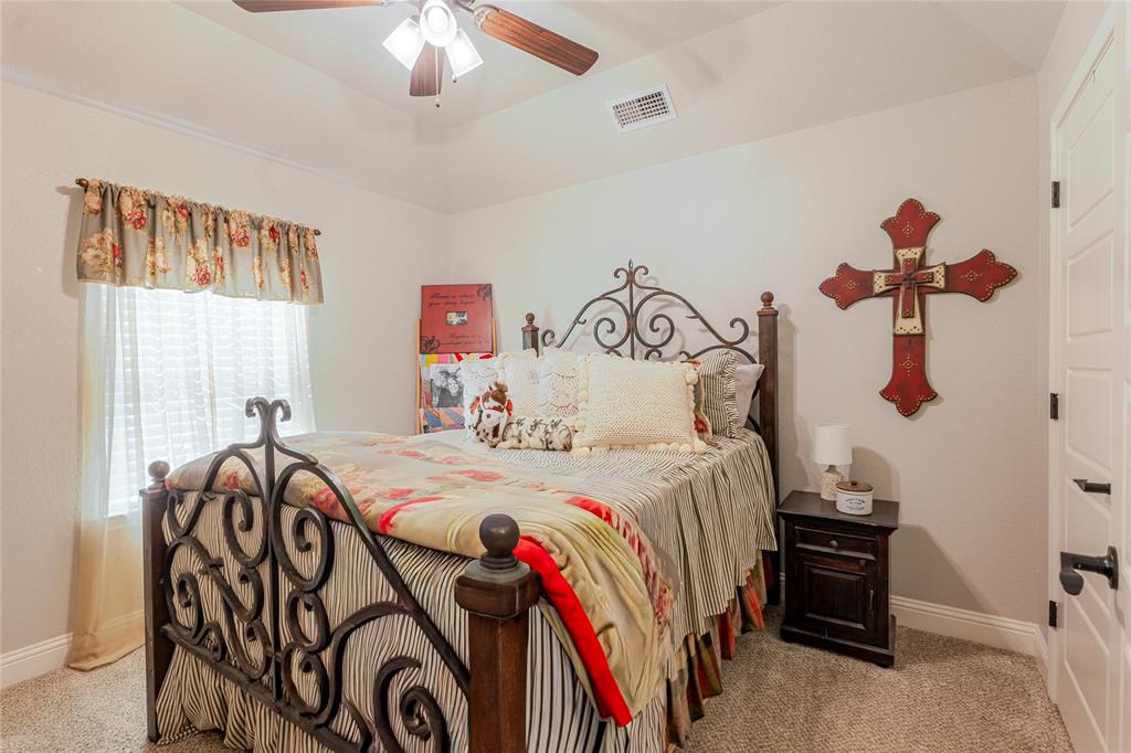 470 Wilson Bend Road Millsap, TX 76066 - Photo 22 of 39 a bedroom with a bed and a chandelier