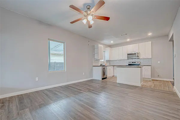 a view of kitchen with granite countertop window and white cabinets