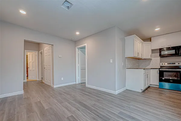 a view of kitchen with wooden floor electronic appliances and window