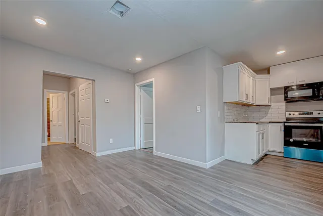 a view of kitchen with wooden floor electronic appliances and window