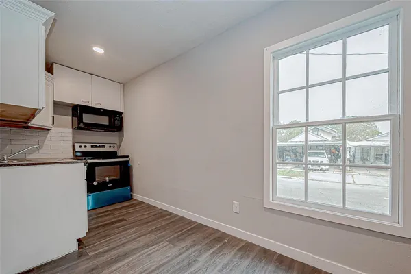 a kitchen with wooden cabinets and a wooden floor