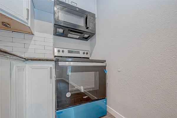 a room with a stove and a microwave