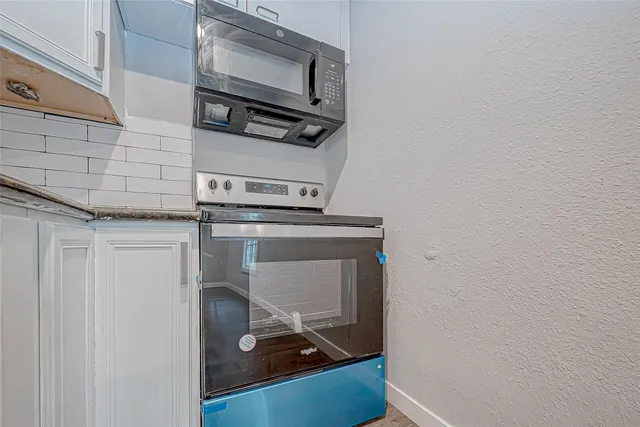 a room with a stove and a microwave