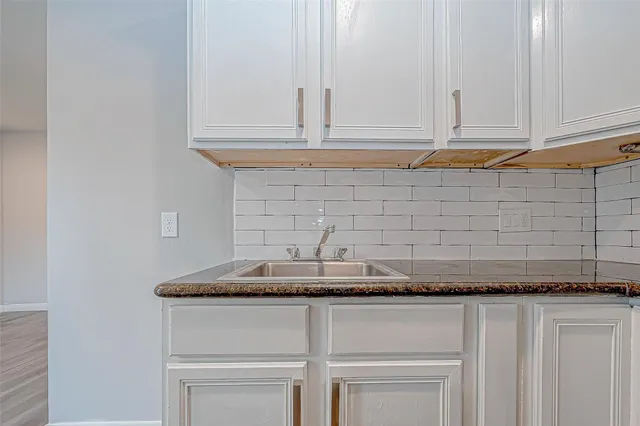 a kitchen with granite countertop white cabinets and a white stove