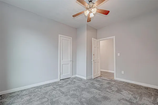 an empty room with closet and a chandelier fan