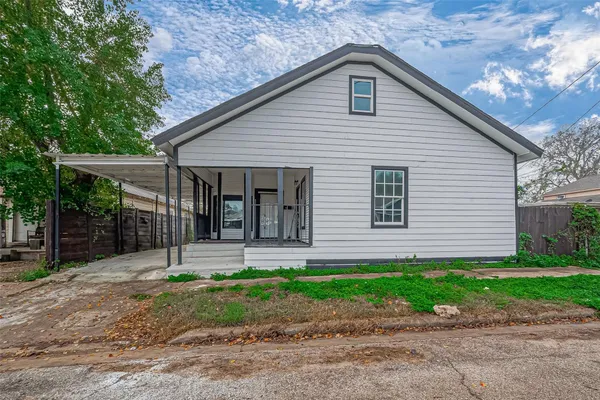 a front view of a house with a garden and plants