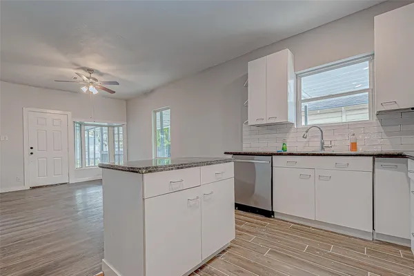a kitchen with granite countertop white cabinets and white appliances