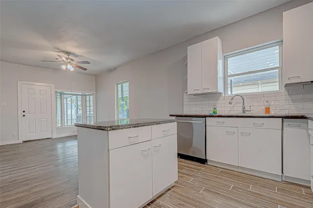 a kitchen with granite countertop white cabinets and white appliances