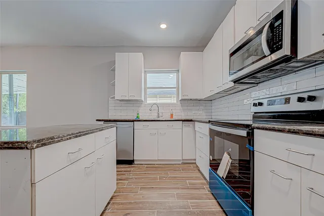 a kitchen with stainless steel appliances granite countertop a sink and cabinets