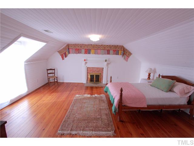 222 Ned Moore Road Timberlake, NC 27583 - Photo 11 of 22 a bedroom with a bed and a dresser with wooden floor