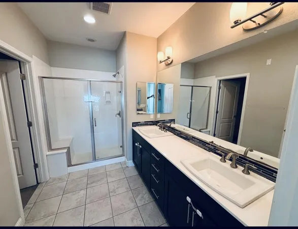 a bathroom with a double vanity sink mirror double and shower