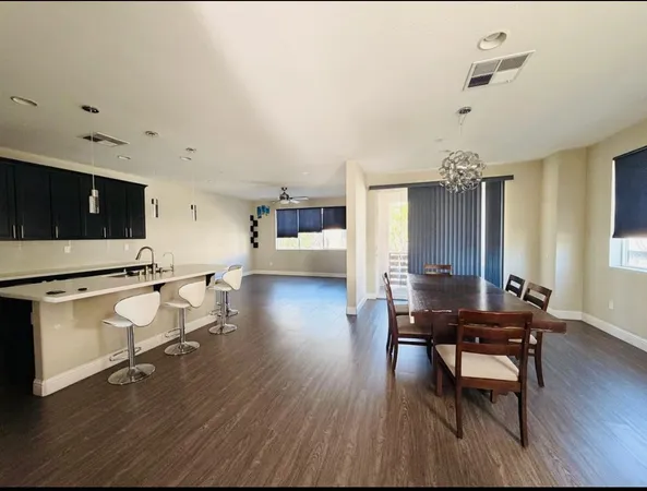 a living room with furniture a dining table and wooden floor