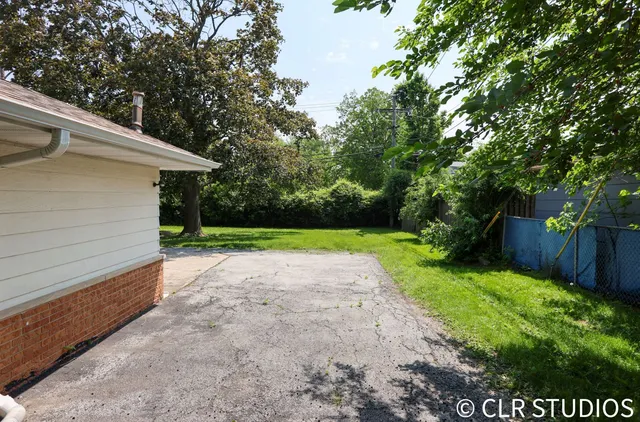 a view of a yard with wooden fence