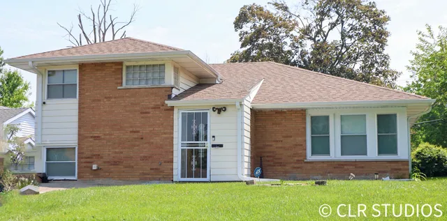 a view of a brick house with a large windows and a yard
